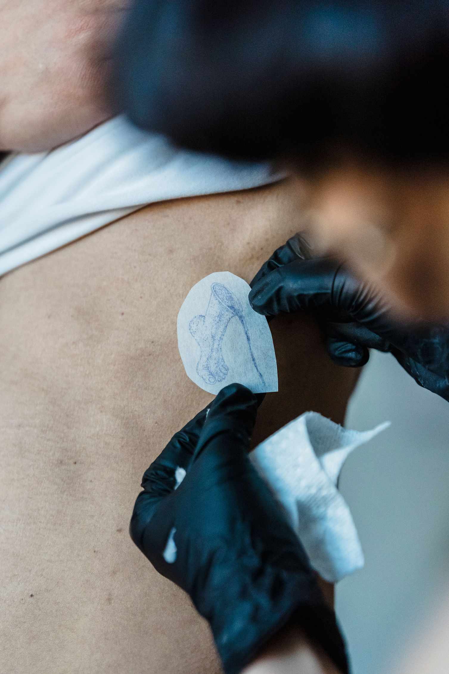 gloved-artist-positioning-tattoo-stencil